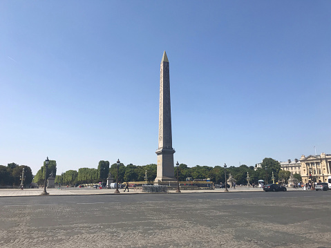 Paris, France : 07/23/2019 - The Luxor Obelisk at Place de la Concorde near The Obelisk of Luxor against blue sky during summer day