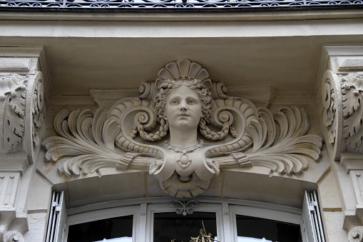 A stone face on a wall in the heart of Paris