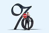 Man Holds A Stop Sign In Front Of Large Percentage Sign