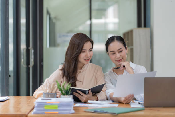 istock Two Young Asian businesswomen discuss with new startup project Idea presentation and analyze planning and financial statistics and investment market at an office. 1491138259