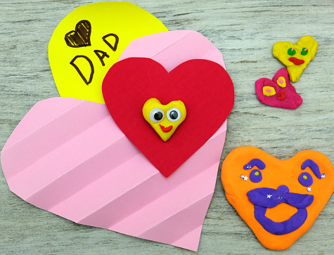 Fathers day, Birthday or Valentines day . Child making funny crafts, greeting card from paper and clay, plasticine.  Arts  crafts concept.