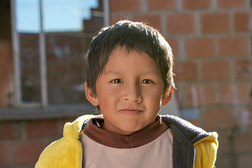 face of a brown-skinned poor latino boy smiling and happy at home in la paz bolivia