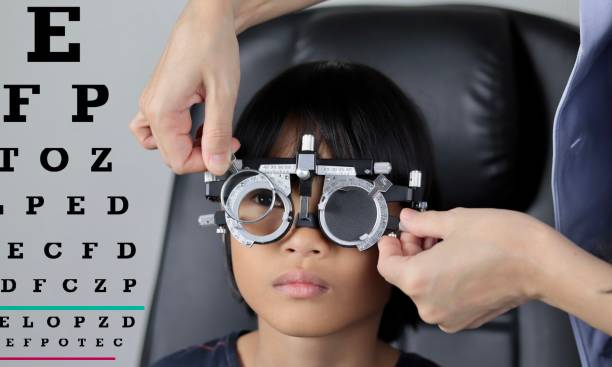 istock Elementary school girl wearing eyeglasses visual acuity test with test chart, eye test, Female patient checking eyesight in ophthalmology clinic, eye check 1491149439