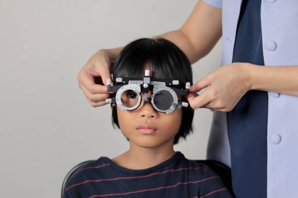 istock Elementary school girl wearing eyeglasses visual acuity test with test chart, eye test, Female patient checking eyesight in ophthalmology clinic, eye check 1491149575