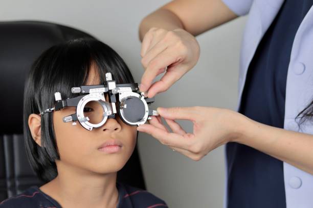 istock Elementary school girl wearing eyeglasses visual acuity test with test chart, eye test, Female patient checking eyesight in ophthalmology clinic, eye check 1491149585