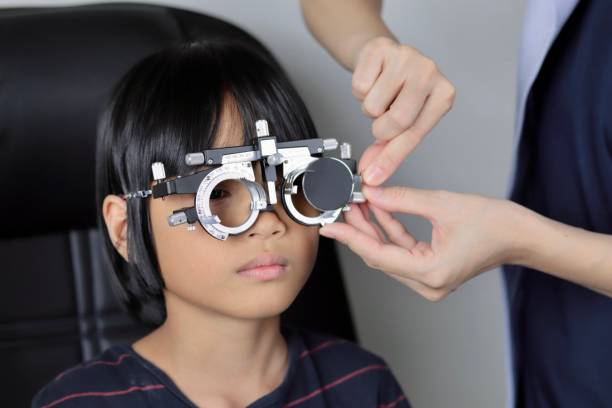 istock Elementary school girl wearing eyeglasses visual acuity test with test chart, eye test, Female patient checking eyesight in ophthalmology clinic, eye check 1491149588