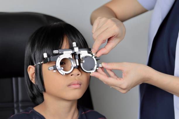 istock Elementary school girl wearing eyeglasses visual acuity test with test chart, eye test, Female patient checking eyesight in ophthalmology clinic, eye check 1491149595