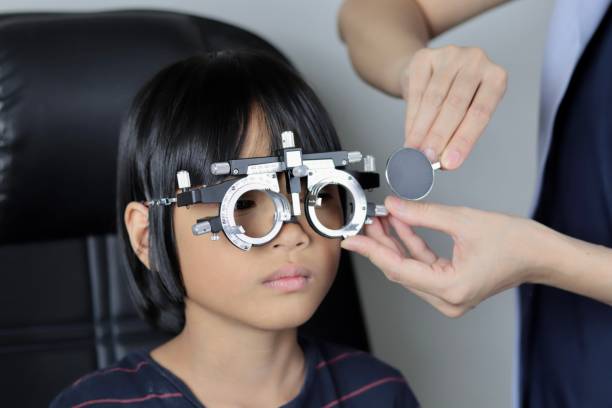 istock Elementary school girl wearing eyeglasses visual acuity test with test chart, eye test, Female patient checking eyesight in ophthalmology clinic, eye check 1491149598