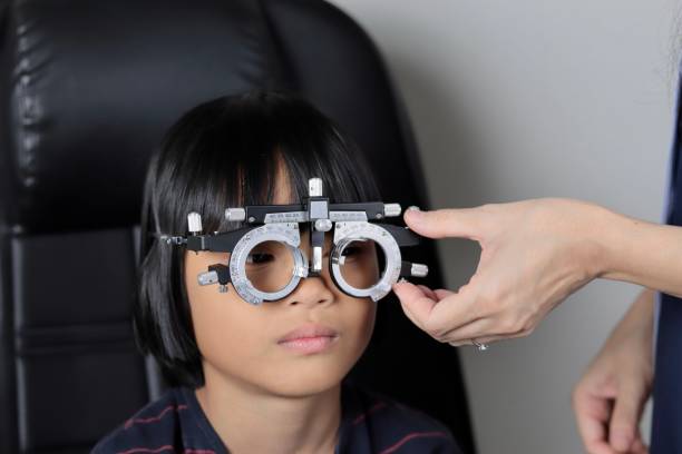 istock Elementary school girl wearing eyeglasses visual acuity test with test chart, eye test, Female patient checking eyesight in ophthalmology clinic, eye check 1491149600