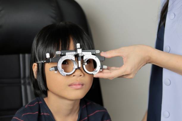 istock Elementary school girl wearing eyeglasses visual acuity test with test chart, eye test, Female patient checking eyesight in ophthalmology clinic, eye check 1491149602