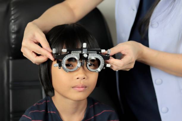istock Elementary school girl wearing eyeglasses visual acuity test with test chart, eye test, Female patient checking eyesight in ophthalmology clinic, eye check 1491149603