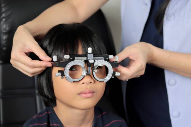 istock Elementary school girl wearing eyeglasses visual acuity test with test chart, eye test, Female patient checking eyesight in ophthalmology clinic, eye check 1491149605
