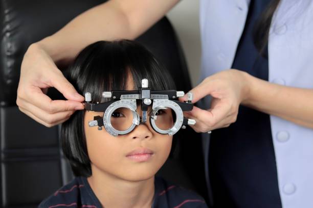 istock Elementary school girl wearing eyeglasses visual acuity test with test chart, eye test, Female patient checking eyesight in ophthalmology clinic, eye check 1491149612