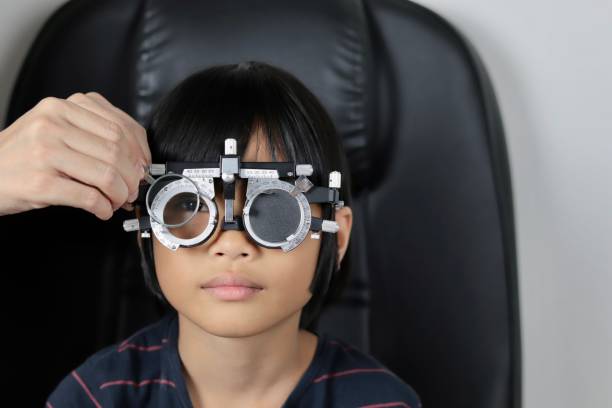 istock Elementary school girl wearing eyeglasses visual acuity test with test chart, eye test, Female patient checking eyesight in ophthalmology clinic, eye check 1491149616