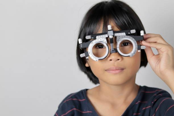 istock Elementary school girl wearing eyeglasses visual acuity test with test chart, eye test, Female patient checking eyesight in ophthalmology clinic, eye check 1491149625