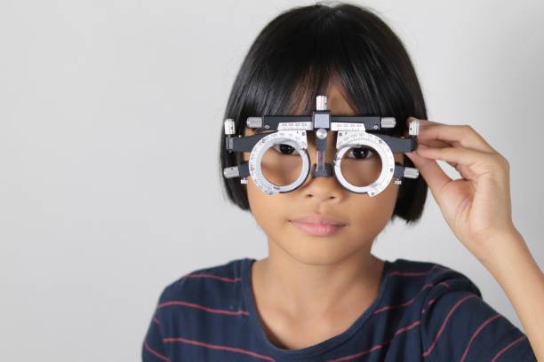 istock Elementary school girl wearing eyeglasses visual acuity test with test chart, eye test, Female patient checking eyesight in ophthalmology clinic, eye check 1491149628