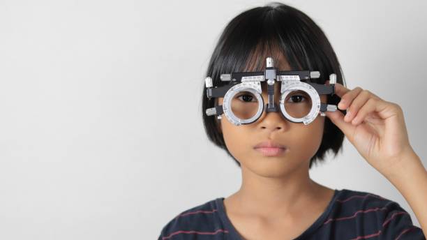 istock Elementary school girl wearing eyeglasses visual acuity test with test chart, eye test, Female patient checking eyesight in ophthalmology clinic, eye check 1491149656