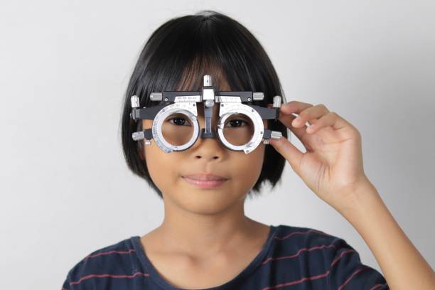 istock Elementary school girl wearing eyeglasses visual acuity test with test chart, eye test, Female patient checking eyesight in ophthalmology clinic, eye check 1491149657