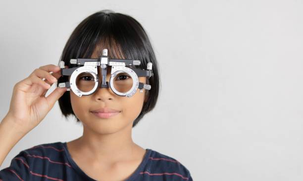 istock Elementary school girl wearing eyeglasses visual acuity test with test chart, eye test, Female patient checking eyesight in ophthalmology clinic, eye check 1491149664