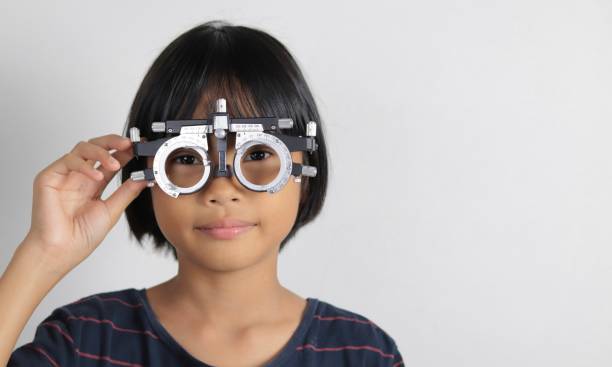 istock Elementary school girl wearing eyeglasses visual acuity test with test chart, eye test, Female patient checking eyesight in ophthalmology clinic, eye check 1491149667