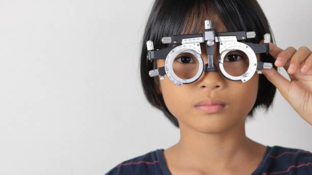 istock Elementary school girl wearing eyeglasses visual acuity test with test chart, eye test, Female patient checking eyesight in ophthalmology clinic, eye check 1491149674