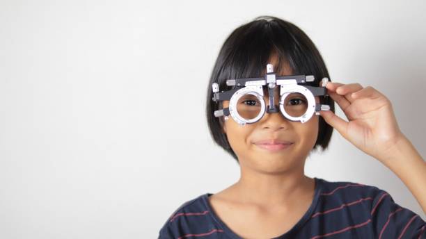 istock Elementary school girl wearing eyeglasses visual acuity test with test chart, eye test, Female patient checking eyesight in ophthalmology clinic, eye check 1491149679