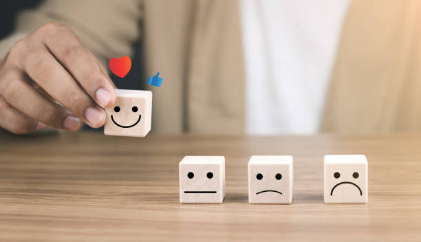 istock Customer Experiences review satisfaction feedback survey concept, satisfaction, Client give rating to service ,feedback review, good quality. Hand of a businessman chooses a smile face on wood block. 1491154616