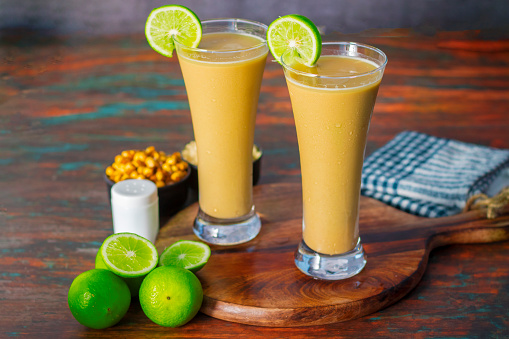 Glass of orange juice on wooden table.