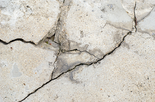 Cracks in the surface of a road or building wall caused by an earthquake