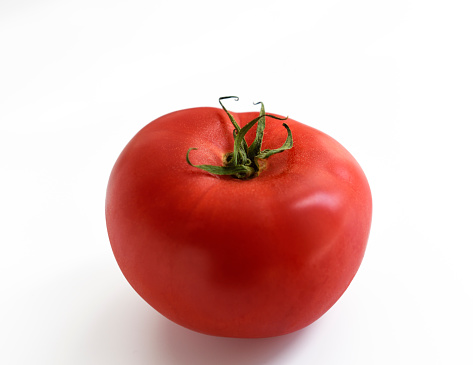 Ripe tomato with shallow depth of field, isolated on white with clipping path.