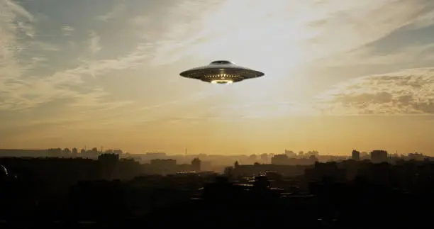 A strange flying machine in the shape of a saucer, silently hovering in the air. It emits a bright light and seems to scan the surrounding space with a beam.