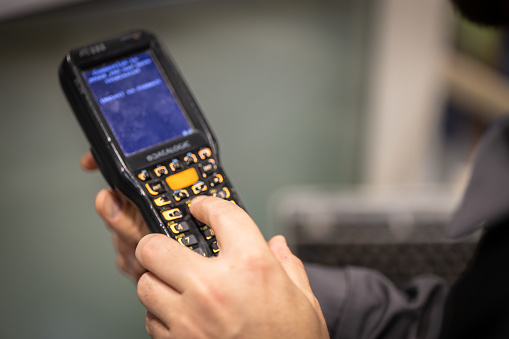 Young warehouse worker using modern technology