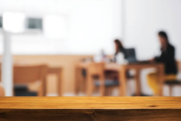 istock Empty wooden desk space over cafe or office background for product display montage. 1491160442