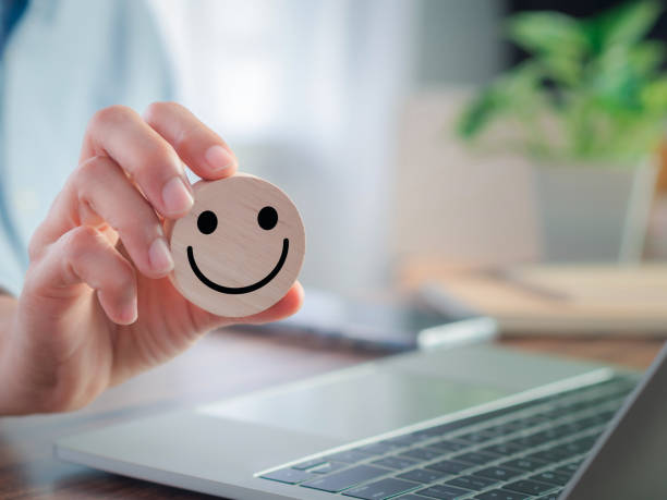 istock Hand-holding circle wooden block with smiley icon. 1491162375