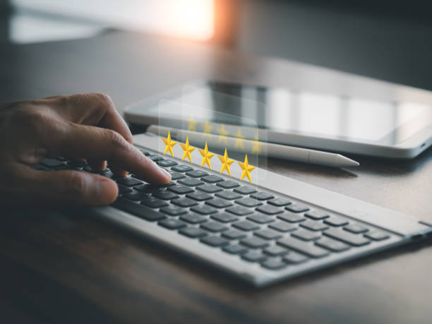 istock Customers rate products or services with 5 stars through online applications on the virtual screen above the computer keyboard. 1491163020