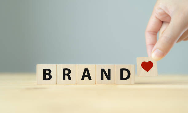 istock Build brand loyalty concept. Customers continue engaging and purchasing from the same brand, positive feelings toward brand. Wooden cube blocks with BRAND text and red heart icon on clean background. 1491163657