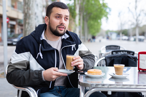 Portrait of european male traveler relaxing in a street cafe