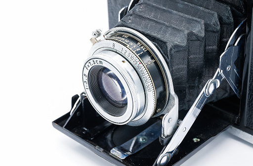 Horizontal angled side shot of an 8×10 glass plate camera manufactured by Folmer and Schwing from approximately 1901  isolated on white.