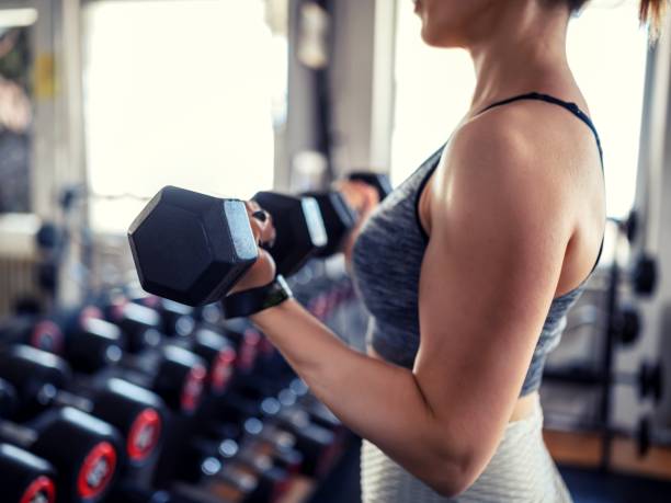 Young woman weightlifting at gym stock photo