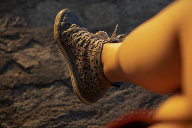 woman legs with blue sneakers sunset