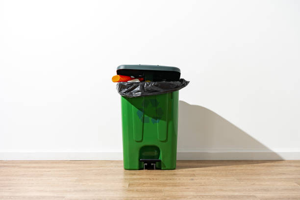istock Green plastic trash can full of garbage indoors 1491177091