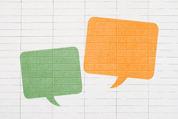 istock Conceptual image about communication and social media, customer feedback, Blank couple speech bubble, green and orange on grunge white brick wall 1491178722