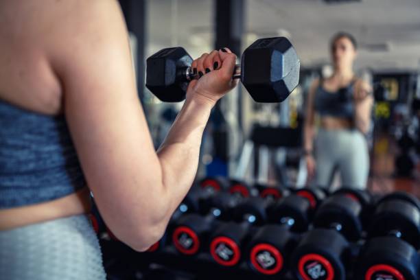 istock Young woman weightlifting at gym 1491178795