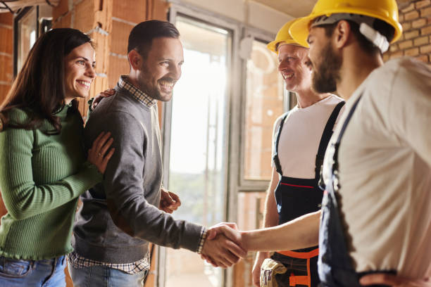 istock Happy manual workers came to an agreement with a couple at construction site. 1491178826