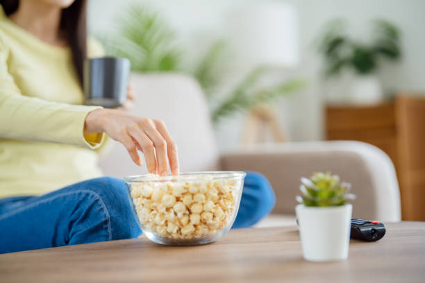 istock Asian woman Watching smart TV and using remote controller Hand holding television audio remote control at home with the remote control television 1491178833