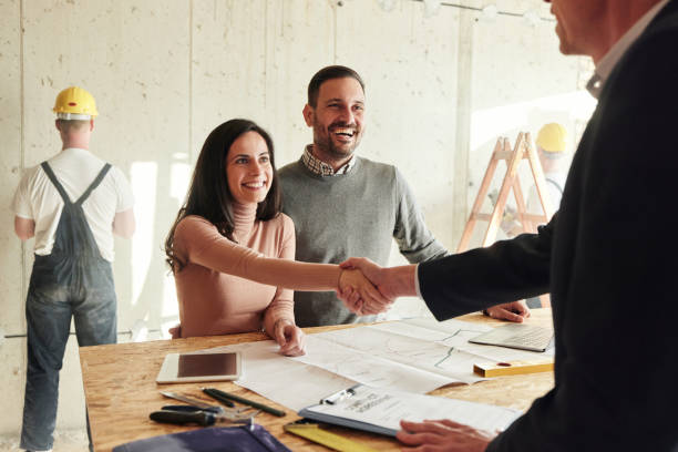 istock Happy couple came to an agreement with agent at construction site. 1491179597