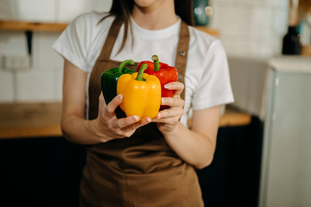istock Fresh bell pepper holding by hand in sun light 1491185429