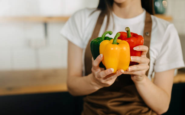 istock Fresh bell pepper holding by hand in sun light 1491185498
