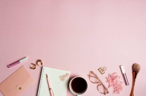 Women items concept with notebook, coffee cup, envelope and make up over the pink background.
