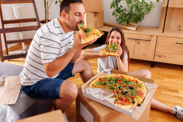 istock Couple eating pizza while moving in together 1491191182